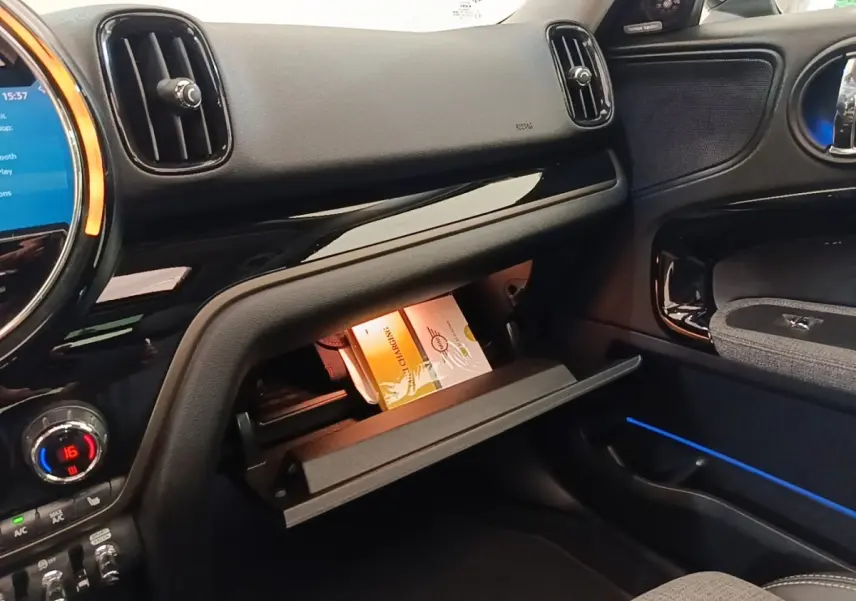 Intérieur côté passager du MINI Countryman noir 2023, boîte à gants ouverte avec notice visible.