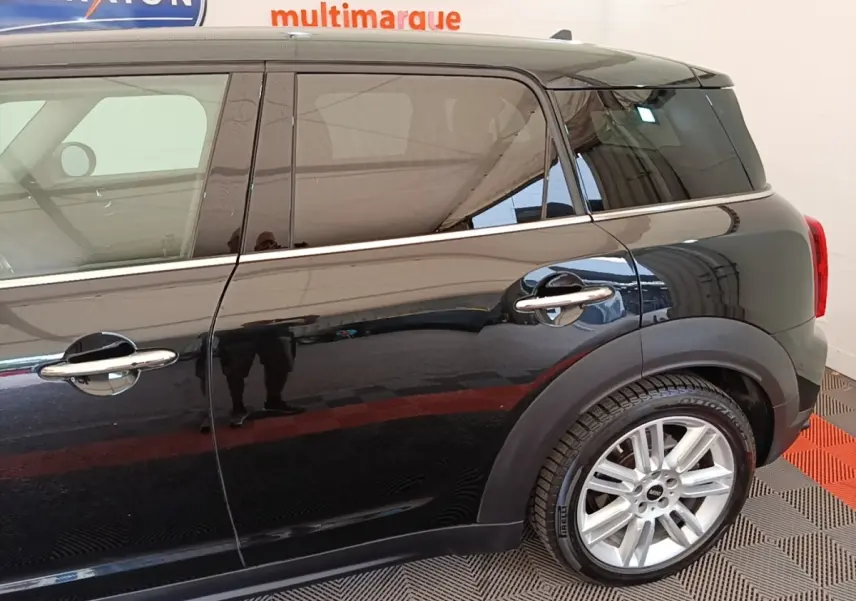 Vue de profil côté droit d'un MINI Countryman noir avec jantes alliage et poignées chromées.