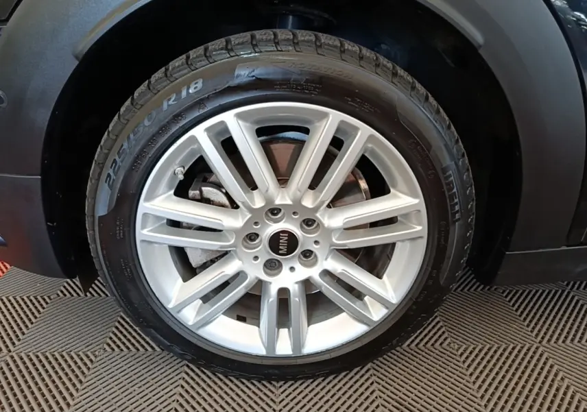 Gros plan sur la roue avant droite argentée du MINI Countryman noir 2023, mettant en valeur la jante et le pneu Pirelli.