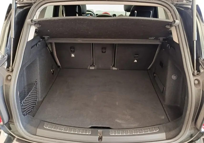 Coffre ouvert noir du MINI COUNTRYMAN Cooper SE 2023, vue arrière montrant l’espace de chargement et la banquette rabattable.