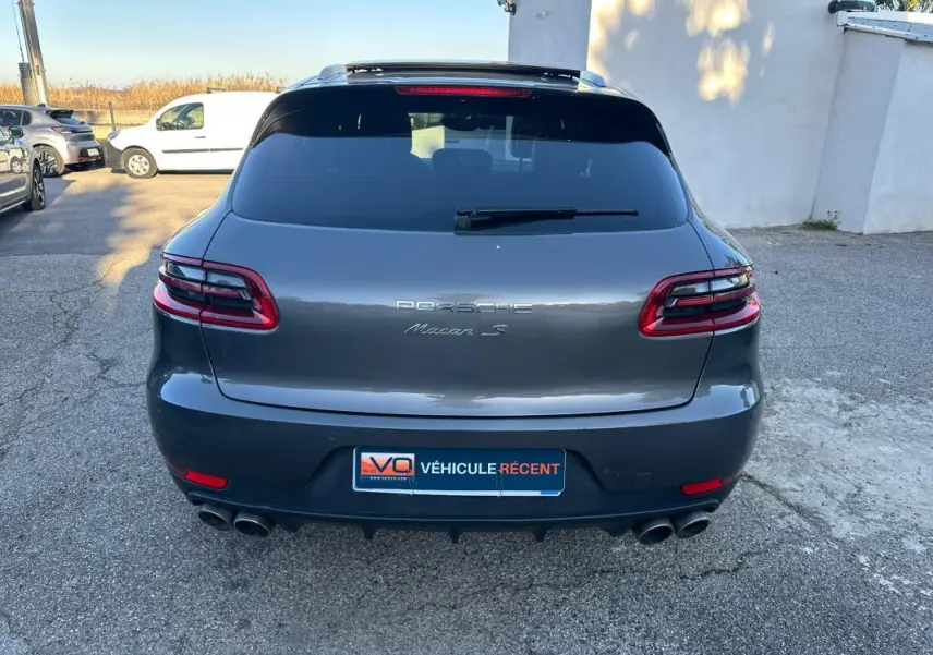 Vue arrière d'un Porsche Macan S gris foncé avec feux LED, double sortie d'échappement et vitre arrière teintée.