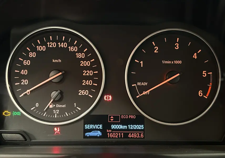 Tableau de bord de BMW Série 1 gris diesel 2014, affichant compte-tours, vitesse et alertes service.