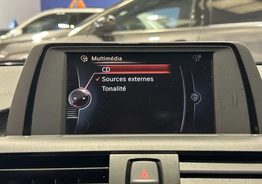 Écran multimédia de la BMW Série 1 16d 2014 affichant les options CD et sources externes, intérieur gris.