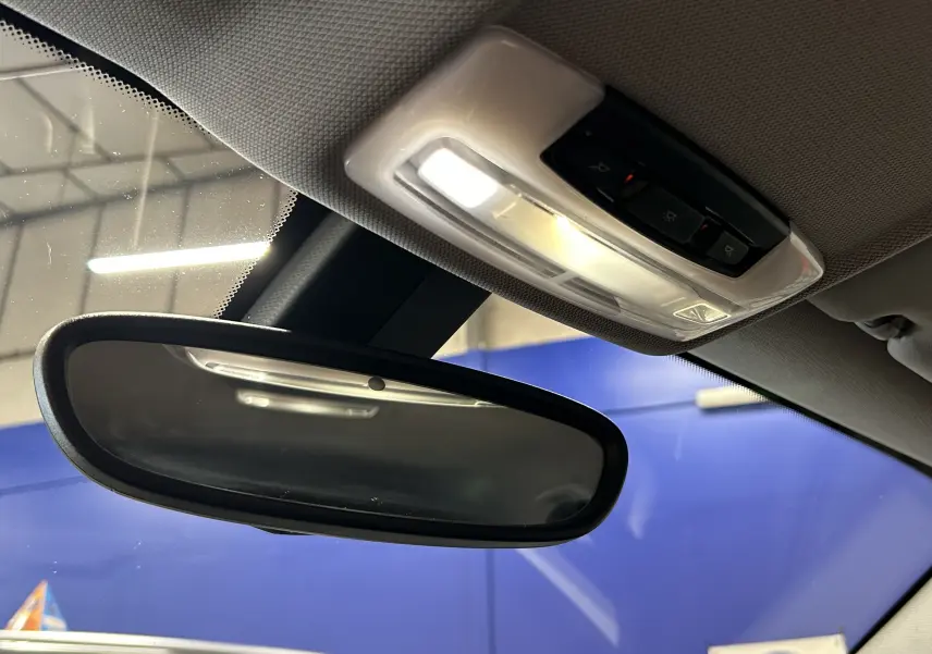 Rétroviseur intérieur et plafonnier avec éclairage allumé dans une BMW Série 1 gris diesel de 2014.