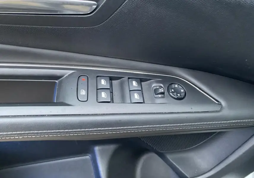 Gros plan sur les commandes de lève-vitres et réglage des rétroviseurs côté conducteur d'un Peugeot 3008 blanc.