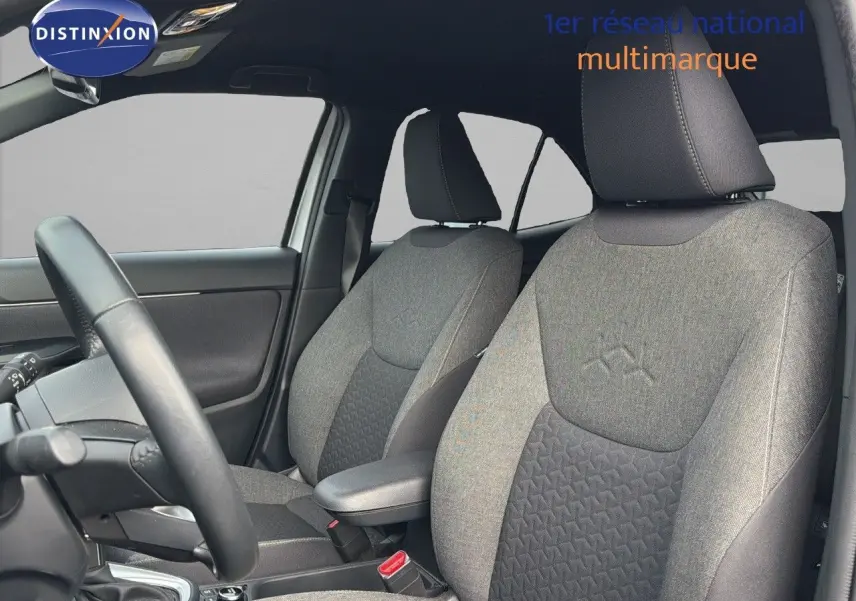 Vue intérieure côté conducteur de la Toyota Yaris Cross 116h Design AWD-i 2023 avec sièges tissu gris et noir.