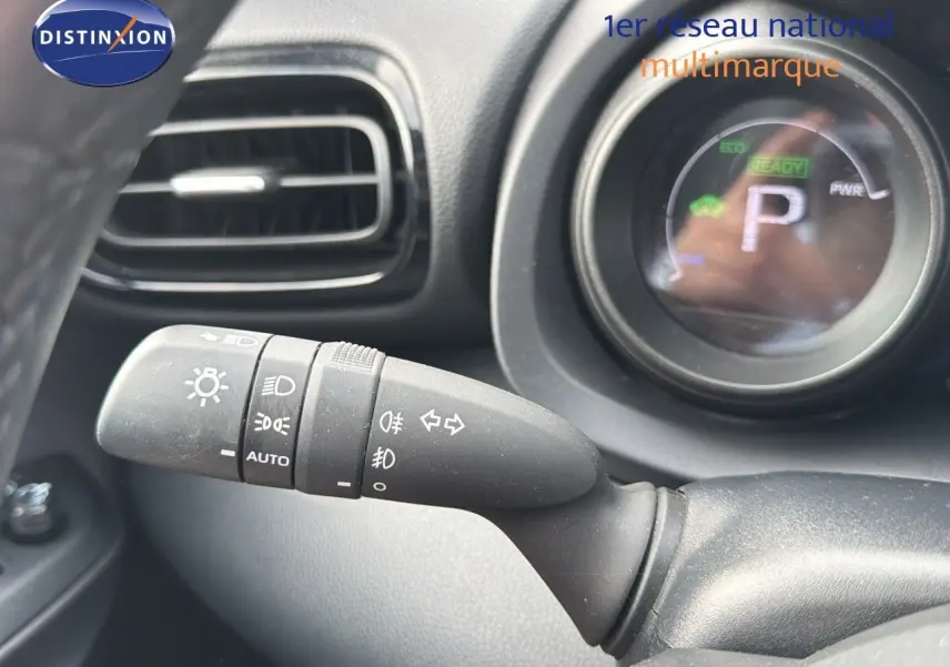Gros plan sur la commande des phares et clignotants dans l'habitacle noir de la Toyota Yaris Cross hybride 2023.