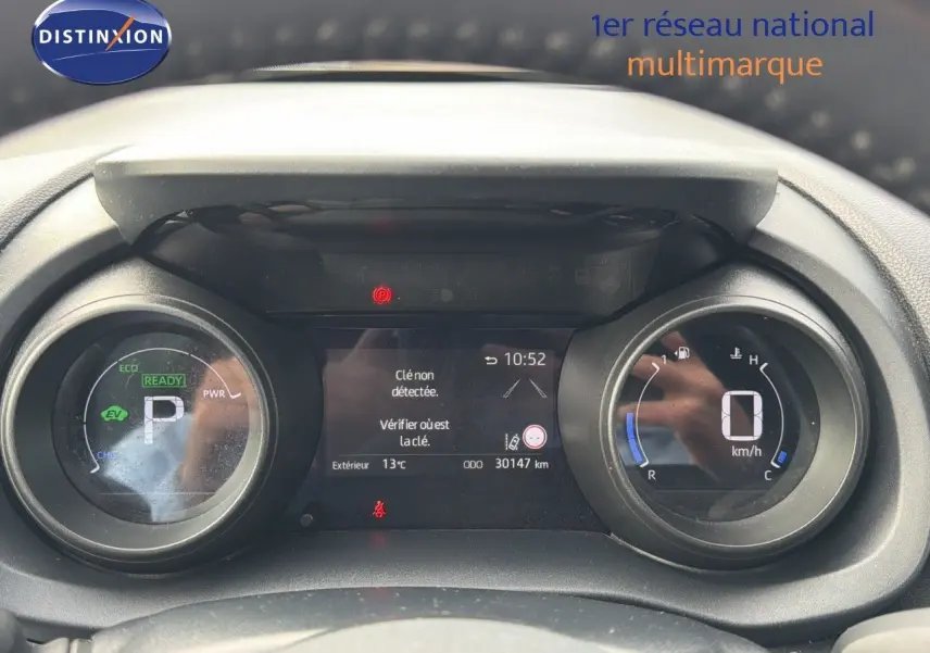 Vue rapprochée du tableau de bord numérique de la Toyota Yaris Cross gris minéral, affichant 30 147 km et indicateurs hybrides.
