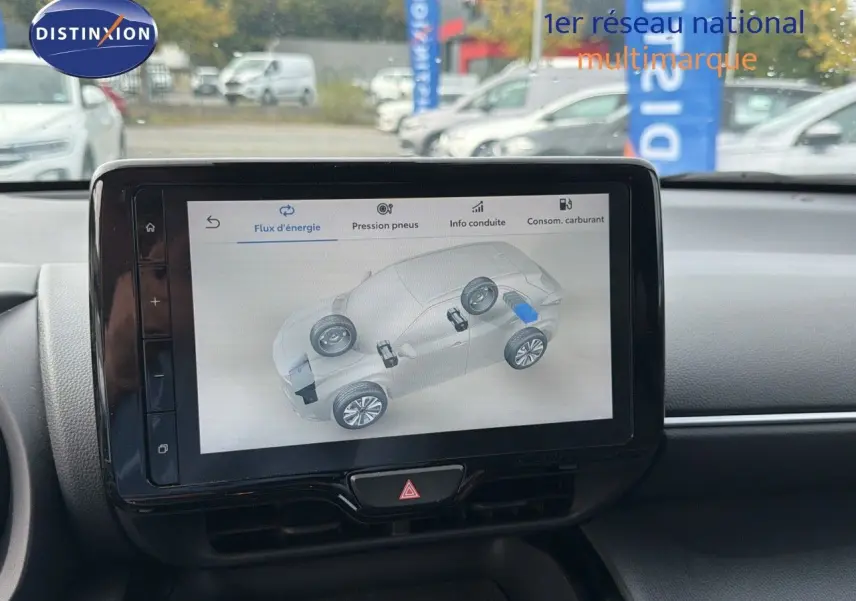 Écran tactile central affichant le flux d'énergie d'une Toyota Yaris Cross hybride, intérieur noir visible.