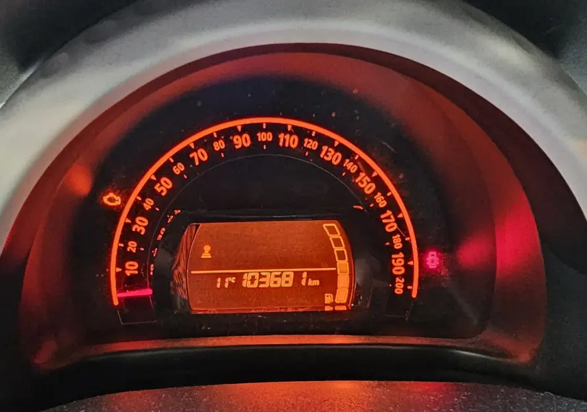 Compteur de vitesse éclairé en orange sur Renault Twingo III gris lunaire, affichant 103681 km et température extérieure 11°C.