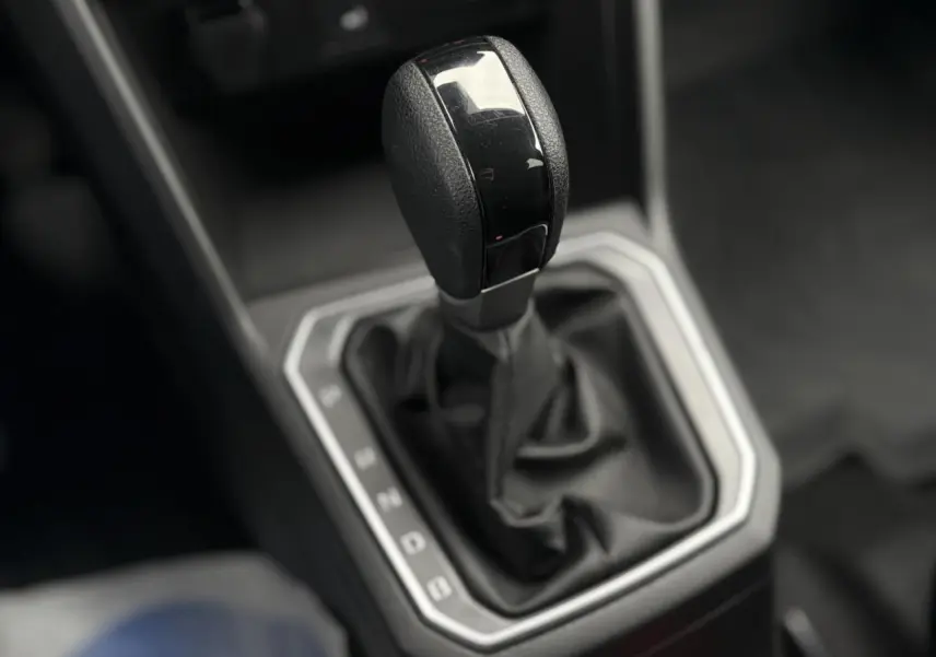 Gros plan sur le levier de vitesses automatique noir du DACIA JOGGER 1.6 Hybrid 140 Extreme 7PL, intérieur sobre.