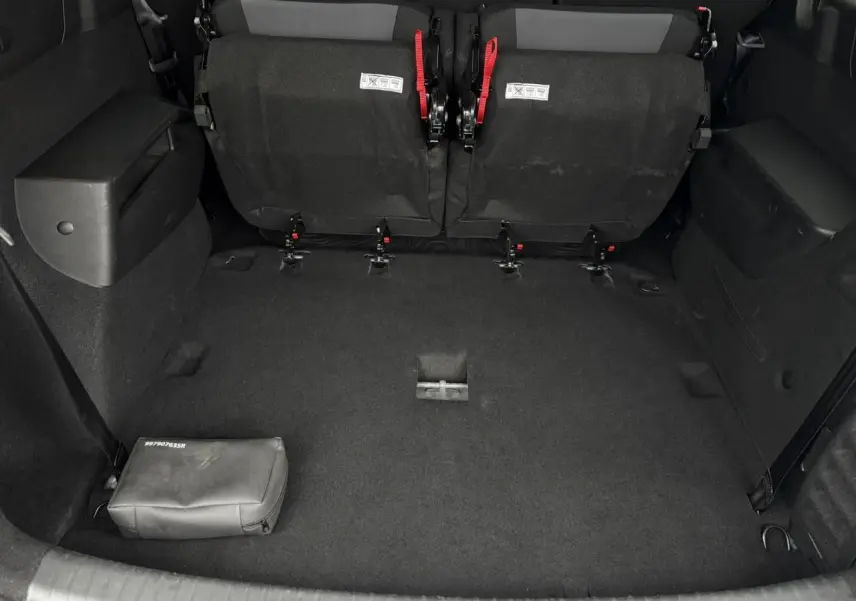 Vue depuis l'arrière du coffre spacieux du Dacia Jogger gris urbain avec les deux sièges du troisième rang relevés.