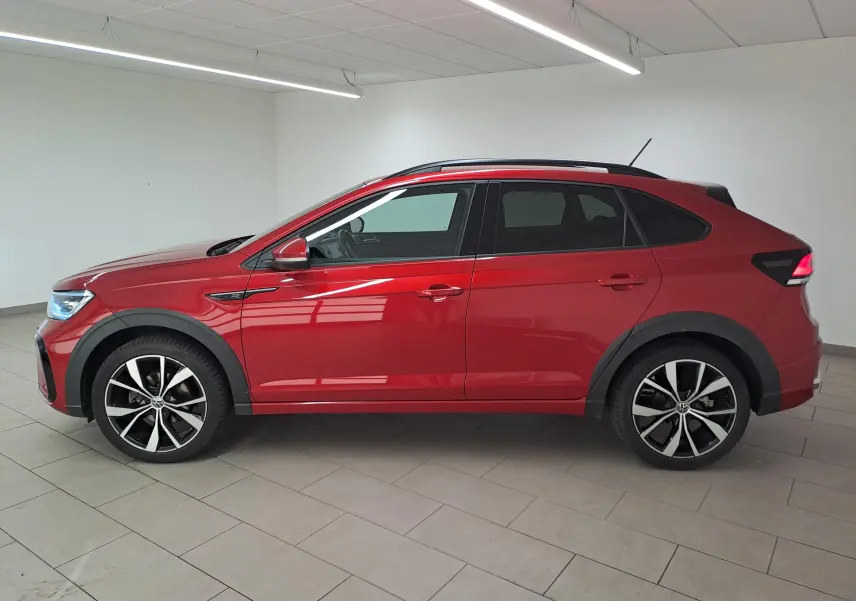 Vue de profil côté gauche d’un Volkswagen Taigo 1.5 TSI 150 DSG7 R-LINE rouge Roi avec jantes alliage noires 18 pouces.