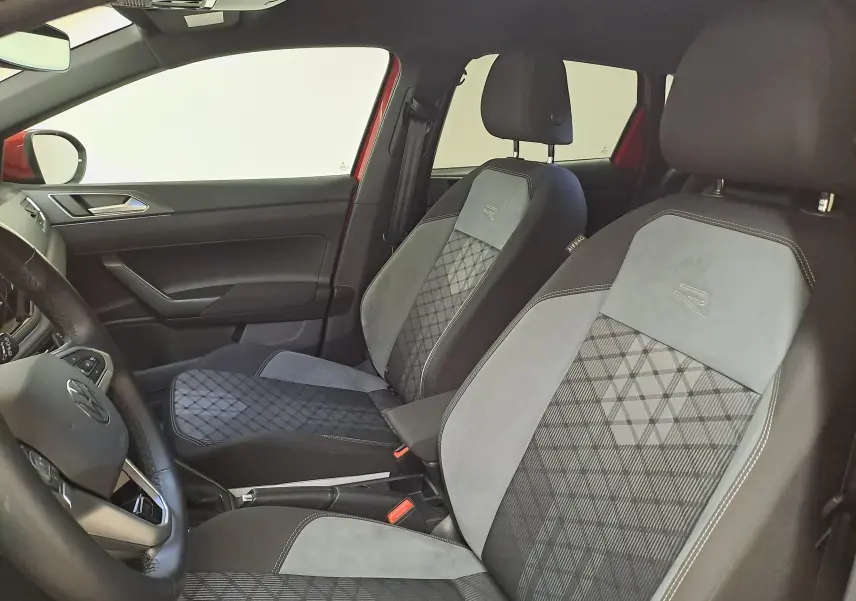 Vue intérieure côté conducteur du Volkswagen Taigo 1.5 TSI R-Line, sièges tissu et alcantara noirs avec surpiqûres grises.