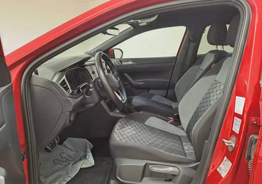 Vue intérieure côté conducteur du Volkswagen Taigo Rouge Roi 2021, sièges tissu noir et gris avec surpiqûres.