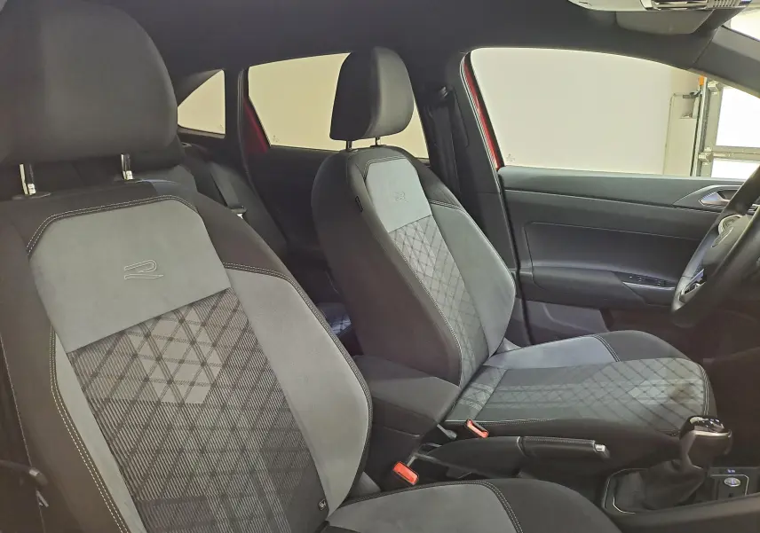 Intérieur avant du Volkswagen Taigo R-Line 2021, sièges tissu et alcantara noirs avec surpiqûres blanches.