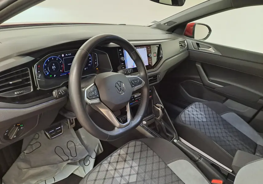 Vue intérieure côté conducteur du Volkswagen Taigo 1.5 TSI R-Line 2021, tableau de bord numérique et sièges tissu gris à motifs.