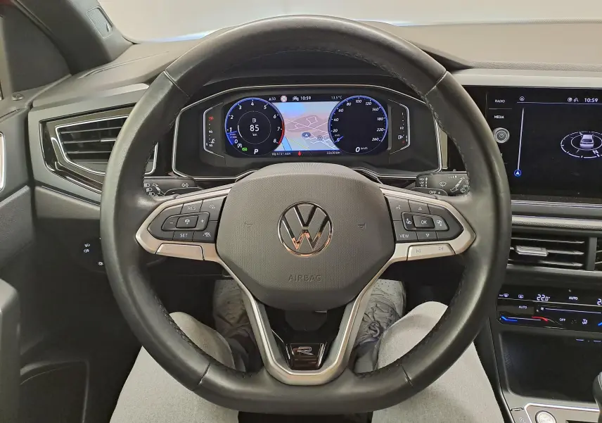 Vue centrée sur le volant cuir noir du Volkswagen Taigo 1.5 TSI R-Line avec tableau de bord digital et écran tactile.