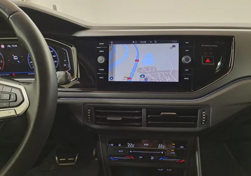 Vue intérieure du tableau de bord du Volkswagen Taigo 1.5 TSI R-Line avec écran tactile de navigation et volant partiel visible.