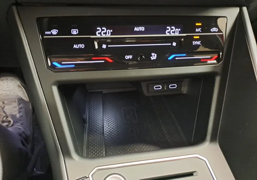 Vue rapprochée du tableau de bord central du Volkswagen Taigo 1.5 TSI 150 DSG7 R-LINE avec commandes climatisation et ports USB.