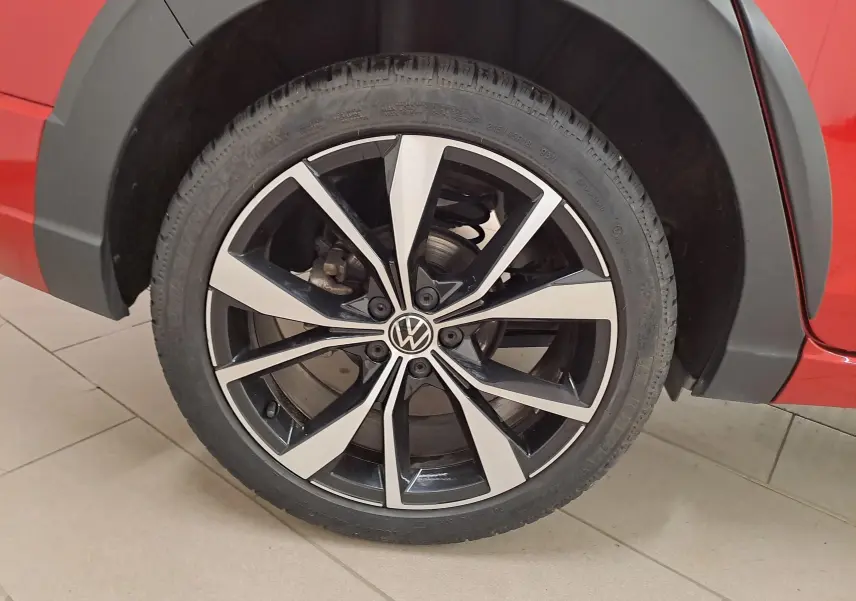 Gros plan sur la jante alliage noire et brillante 18 pouces du côté arrière droit d’un Volkswagen Taigo Rouge Roi.