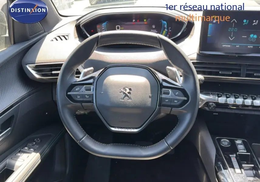 Vue intérieure centrée sur le volant cuir noir du Peugeot 3008 Hybrid 2024 avec tableau de bord numérique et écran tactile.