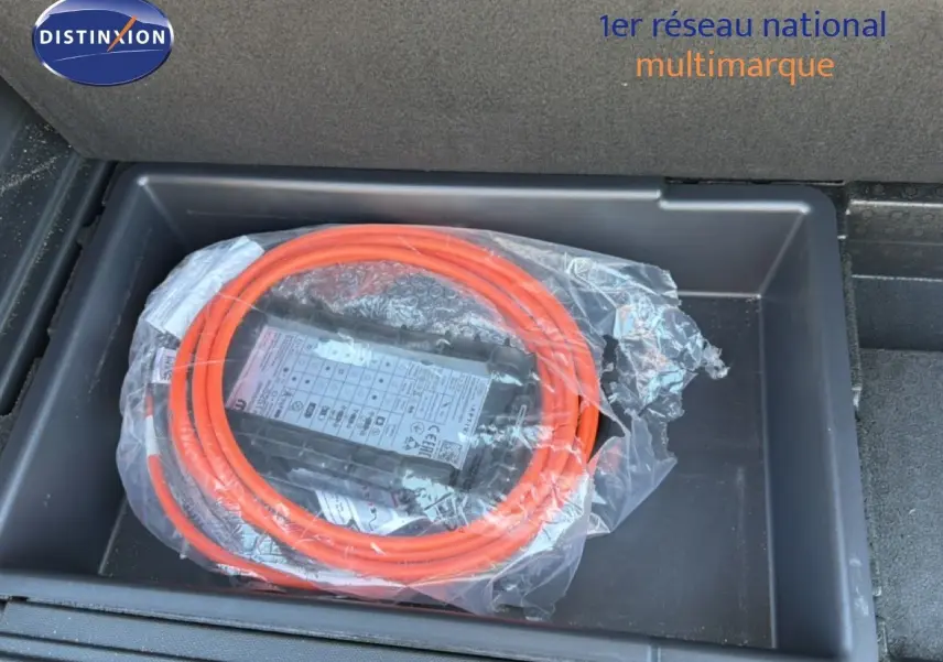 Coffre ouvert du Peugeot 3008 Hybrid 180ch gris Artense, montrant le câble de recharge hybride orange rangé.