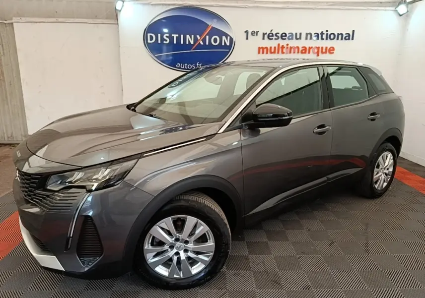 Peugeot 3008 gris foncé vue 3/4 avant droit en intérieur, avec jantes alliage et calandre distinctive.