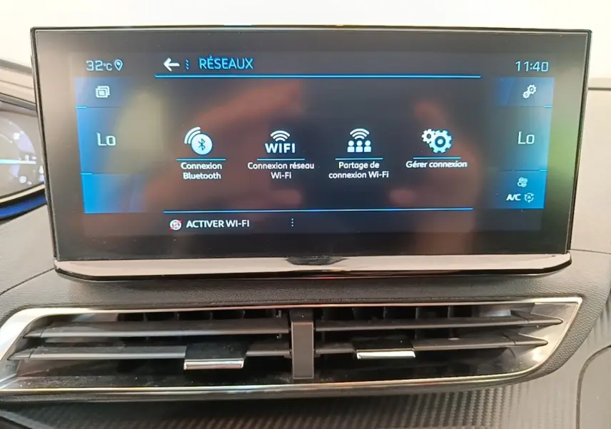 Écran tactile central du tableau de bord du Peugeot 3008 gris foncé, affichant les options de connexion Wi-Fi et Bluetooth.