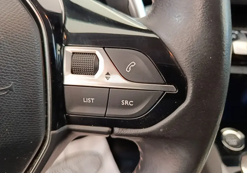 Gros plan sur le côté gauche du volant cuir noir du Peugeot 3008 2022 avec commandes multifonctions et bouton appel.