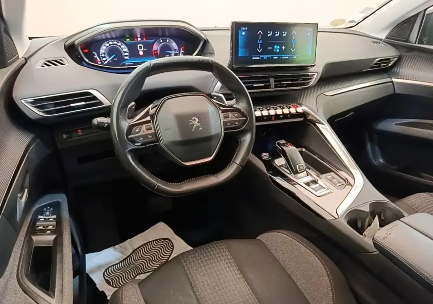 Vue intérieure avant du Peugeot 3008 2022, volant cuir multifonctions et écran tactile central lumineux.