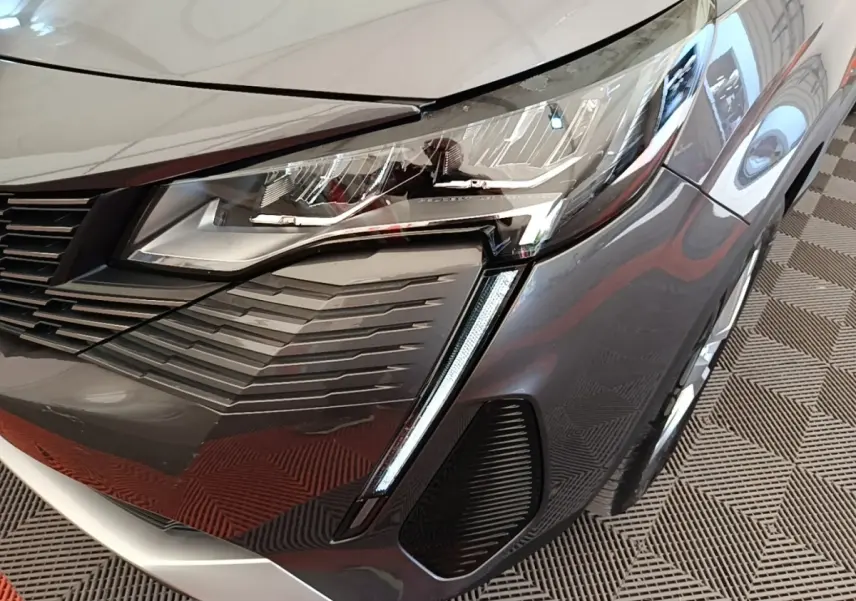 Gros plan sur le phare avant droit du Peugeot 3008 gris foncé avec signature lumineuse LED verticale.