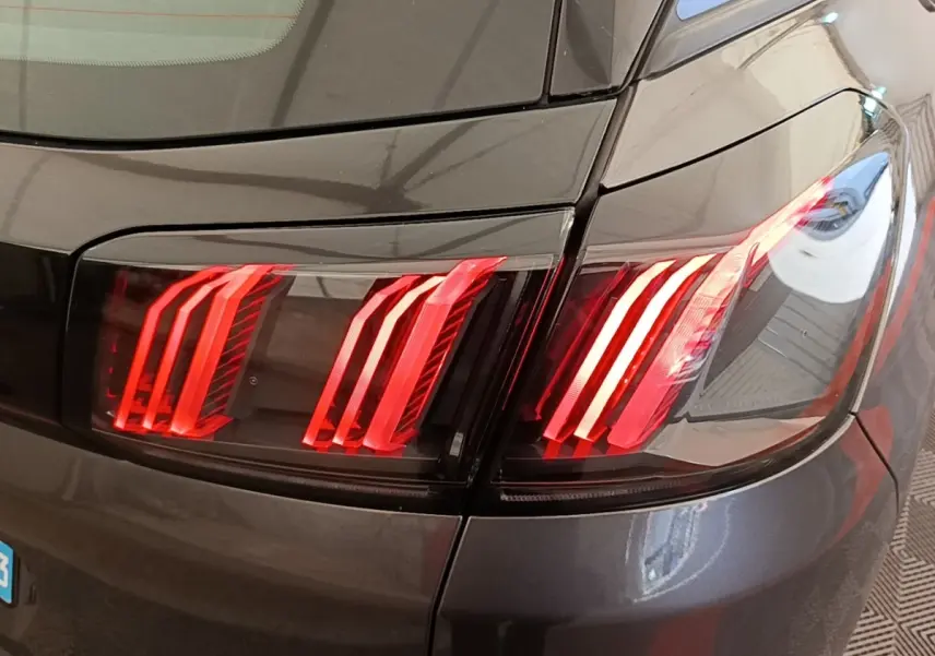 Gros plan sur le feu arrière droit rouge du Peugeot 3008 gris foncé, mettant en valeur ses lignes LED distinctives.