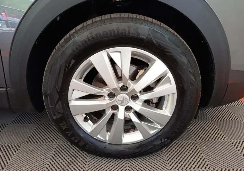 Gros plan sur la roue avant droite du Peugeot 3008 gris foncé, mettant en valeur la jante alliage et le pneu Continental.