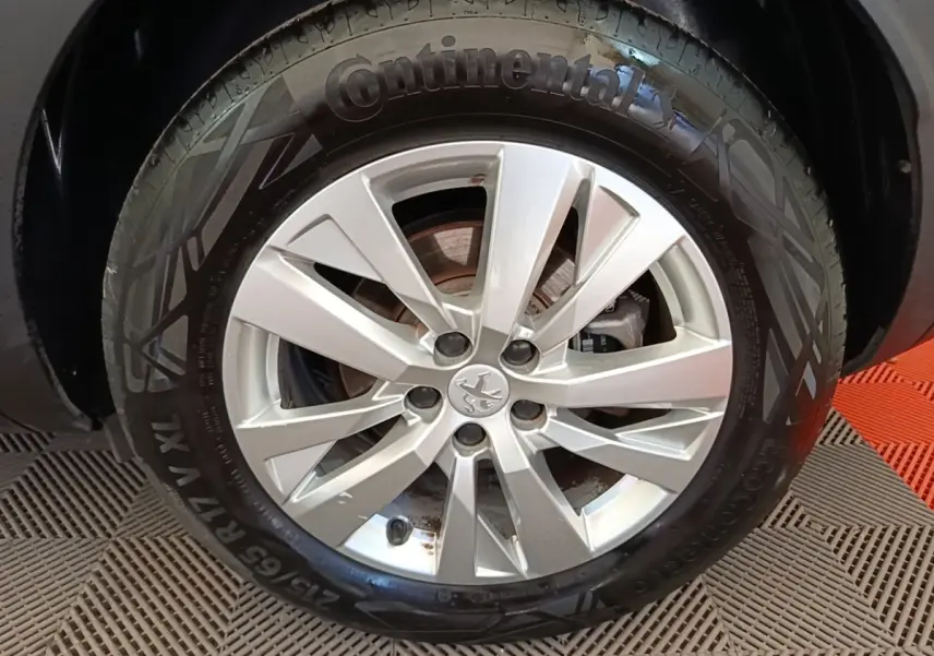 Gros plan sur la roue avant droite d’un Peugeot 3008 gris foncé avec jante alliage et pneu Continental.