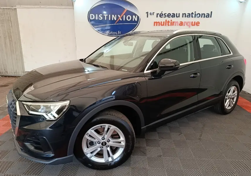 Audi Q3 hybride rechargeable 2023 vue 3/4 avant droit, carrosserie noire brillante avec jantes argentées et phares LED.