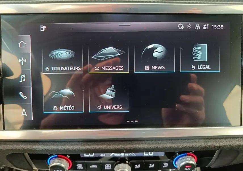Écran tactile central de l’Audi Q3 45 TFSI e 2023 affichant les menus utilisateurs, messages, news, météo et univers.
