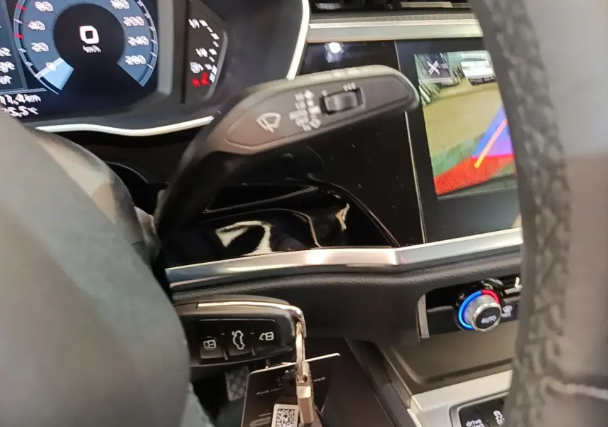 Vue intérieure du tableau de bord de l'Audi Q3 45 TFSI E 2023 avec affichage numérique et commande de climatisation.