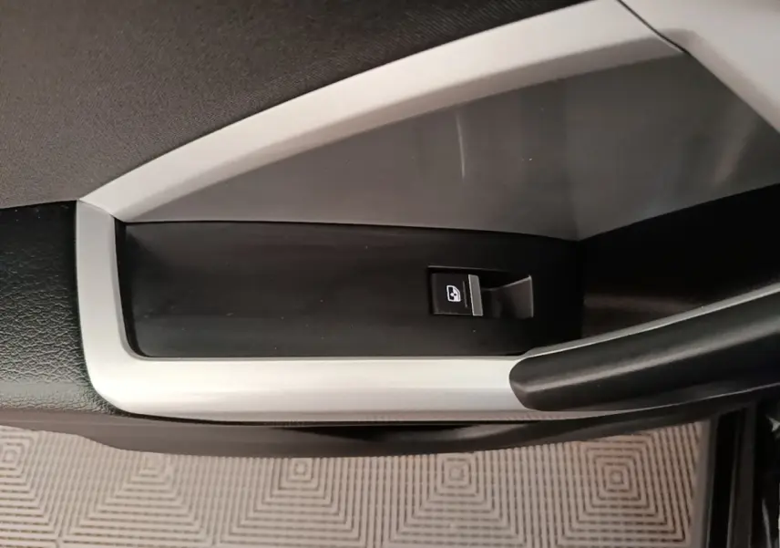 Détail de la commande de lève-vitre côté gauche intérieur de l'Audi Q3 45 TFSI e 2023 avec insert argenté.