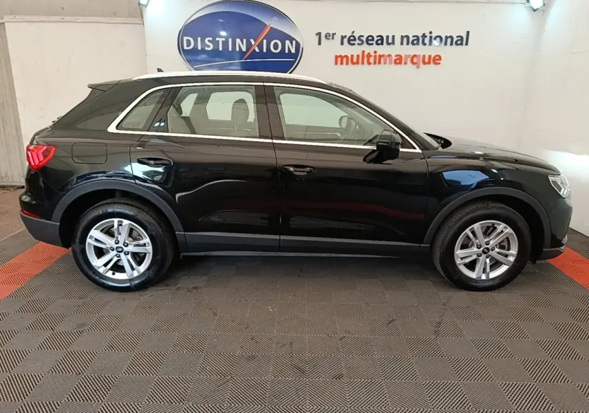 Vue latérale droite d'un Audi Q3 45 TFSI e hybride rechargeable noir, avec jantes alliage et rails de toit chromés.