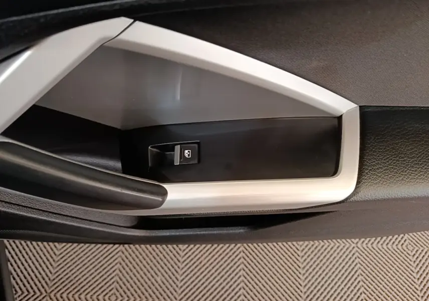 Gros plan sur la commande de lève-vitre côté gauche de la porte intérieure noire et grise de l'Audi Q3 2023.