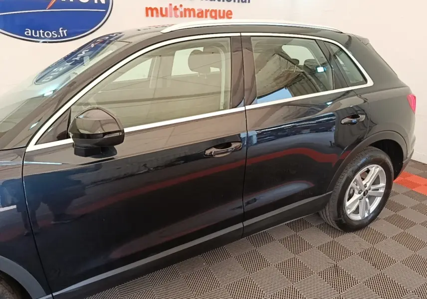 Vue de profil côté gauche d’un Audi Q3 hybride rechargeable 2023 noir avec jantes alliage et rétroviseurs noirs.