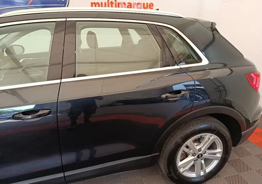 Vue latérale côté droit d’un Audi Q3 hybride rechargeable 2023 noir avec jantes alliage et vitres teintées.