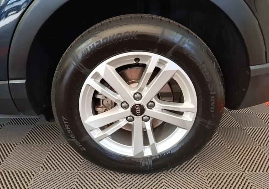Gros plan sur la roue avant droite argentée d’un Audi Q3 45 TFSI e 245 S tronic Business Line, carrosserie noire.