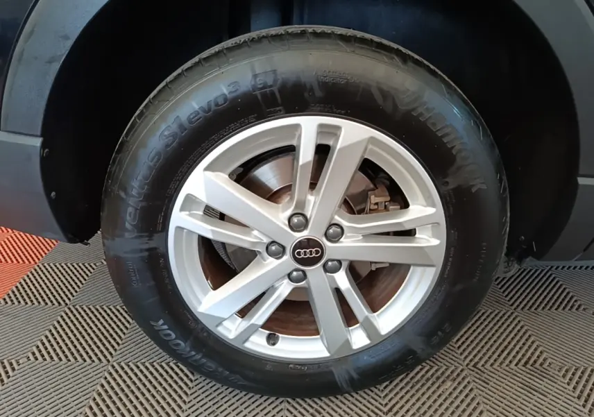 Gros plan sur la roue avant droite d’un Audi Q3 45 TFSI e avec jante argentée et pneu Hankook noir.