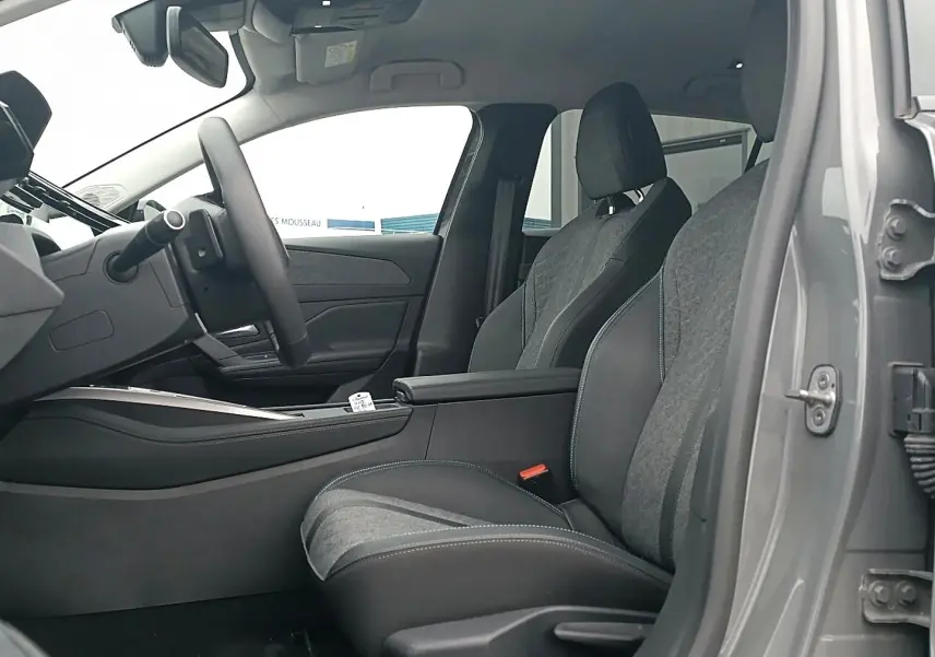 Vue intérieure côté conducteur de la Peugeot 408 Hybrid 145 allure gris sellenium avec sièges bi-matière et accoudoir central.