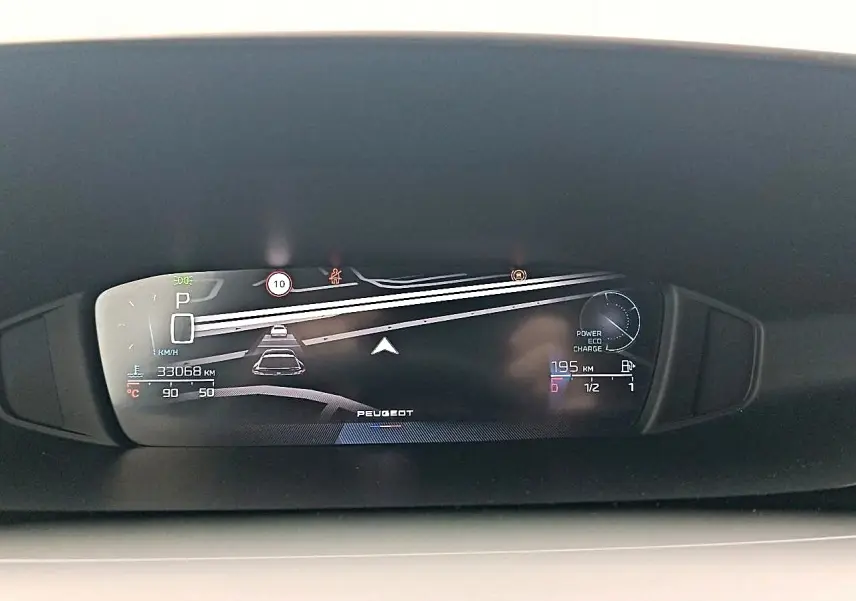 Affichage numérique du tableau de bord de la Peugeot 408 Hybrid 145 allure, montrant la vitesse et l'autonomie restante.