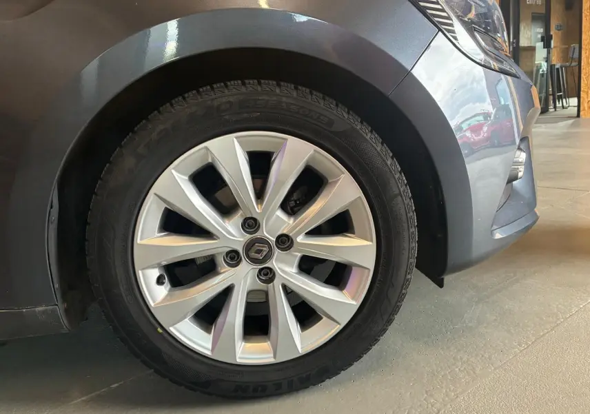 Gros plan sur la roue avant gauche grise d'une Renault Clio 1.0 TCE 100 Intens avec jante alliage moderne.