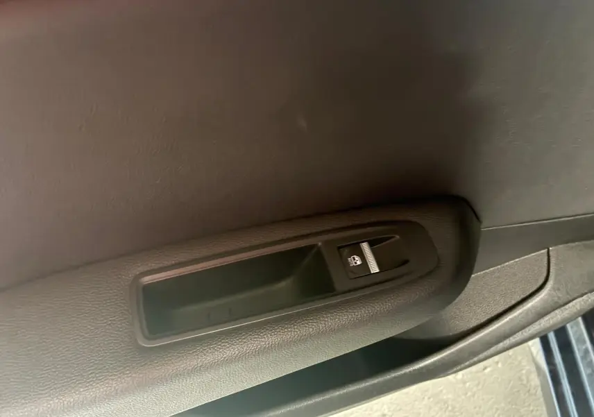 Bouton de commande de lève-vitre sur la portière intérieure côté droit d'une Renault Clio gris 2020.