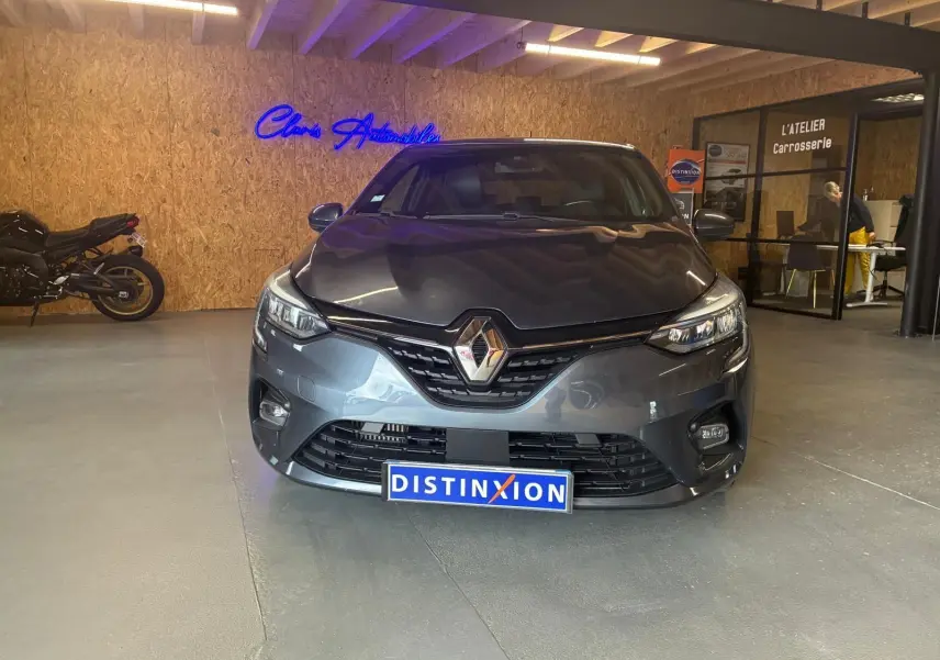 Vue frontale d'une Renault Clio gris métallisé 2020, avec calandre noire et logo Renault bien visible.